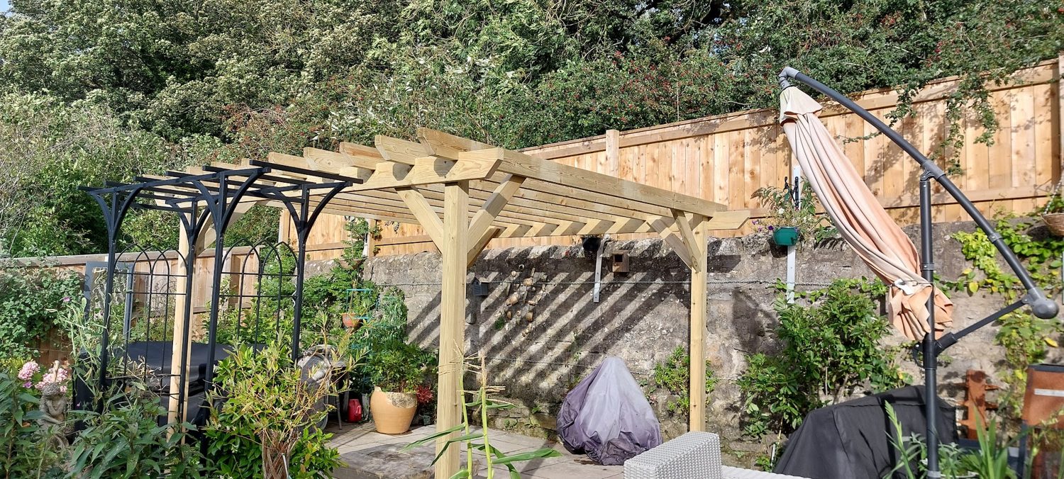 A timber pergola in a planted garden