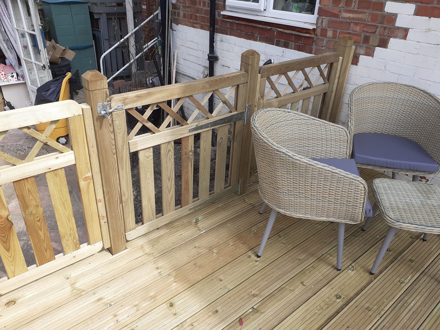A deck with a balustrade and wicker chairs