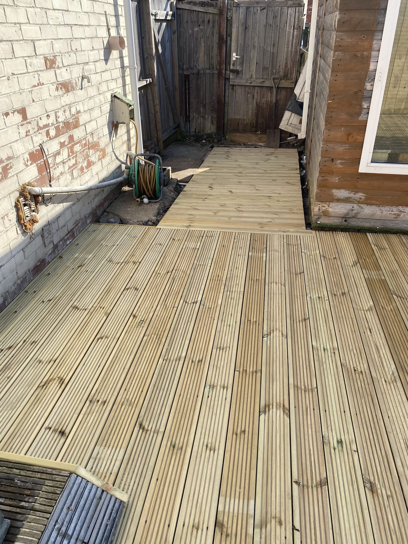 A new two-level deck running down the side of a house